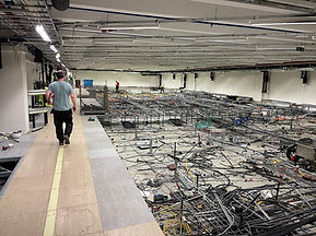 Man går längst kanten av våning två och överblickar arbetsplatsen på plan ett.